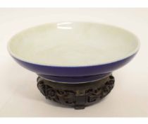 Chinese circular shallow bowl with dark blue glazed underside, five character mark under, carved