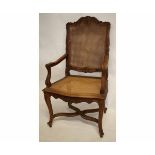 Stained beech carver chair with cane back and seat, arms and back carved with geometric foliage etc