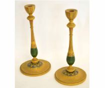 Pair of treen or toleware candlesticks, the wooden body with a green and orange design, 32cms