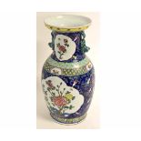 Late 20th century Oriental polychrome baluster vase decorated with reserve panels of flowering
