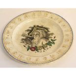 Mid-19th century children's alphabet plate, the centre with an 18th century gentleman with pipe