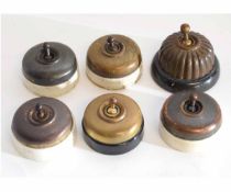 Tub containing six Victorian brass circular light switches with porcelain backs