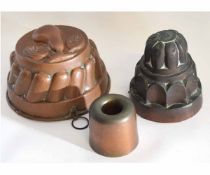 Three copper jelly moulds, one with a pressed pear to top, the other a smaller cylindrical mould,