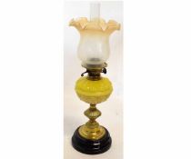 Victorian oil lamp with stepped and reeded brass column on a black slag base with a shaped yellow