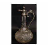 Early 20th century cut glass and pewter mounted claret jug, the handle with grotesque animal finial,