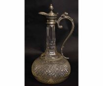 Early 20th century cut glass and pewter mounted claret jug, the handle with grotesque animal finial,