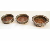Three Victorian silver plated wine coasters with fluted decoration and cast tops, each approx