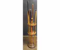 Victorian mahogany formed circular cue stand with a quantity of fitted cues, with turned finial to