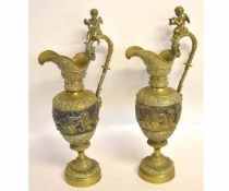 Two large good quality pressed brass ewers with cherub mounted handles and pressed cherub design