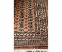 Good quality Bokhara type carpet with terracotta ground with repeating lozenge centre and multi-