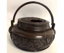 Chinese lidded bronze censer or hand warmer of circular form with double swing handles, 27cms diam