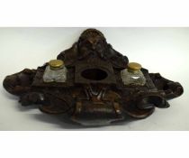 Black Forest type Green Man carved ink stand fitted with two clear glass square formed bottles