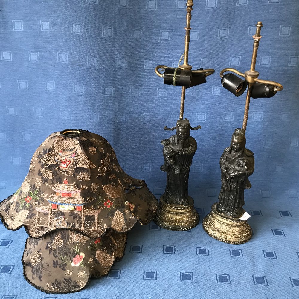 Pair of C19th Chinese bronze figures raised on decorative oval stands, as table lamps with shades