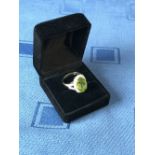 18 carat yellow gold, peridot and diamond ring, the central peridot of 6.3 carats surrounded by 1.
