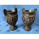 Pair of bronze two handled urns, extravagantly embossed with classical figures, 20cmH