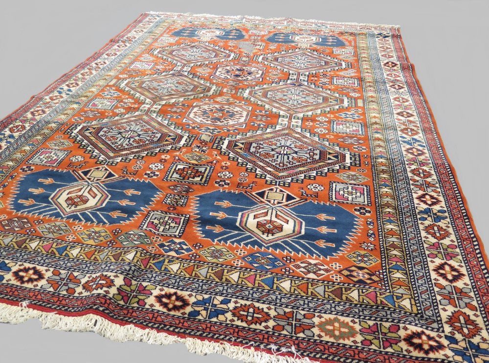 Fine Caucasian rug, with terracotta colour ground and all over medallions of blues and creams &