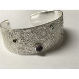 Sterling silver textured open cuff bangle set with cabochon amethyst and faceted blue topaz, citrine