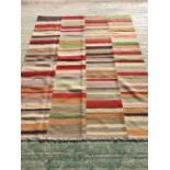 Contemporary rug with bright multi colour, reds, greens, browns and greys of geometric stripe