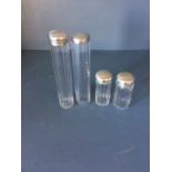 Set of 4 glass ladies vanity bottles with hallmarked silver tops