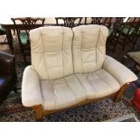 Ekornes 2 seater reclining sofa in cream leather covering with oak effect frame 70x148cm