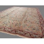 European carpet with traditional designs of grey and pink flowers with scrolling leaves light