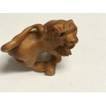 Unusual wooden Japanese Netsuke in the form of a lion, signed to the base