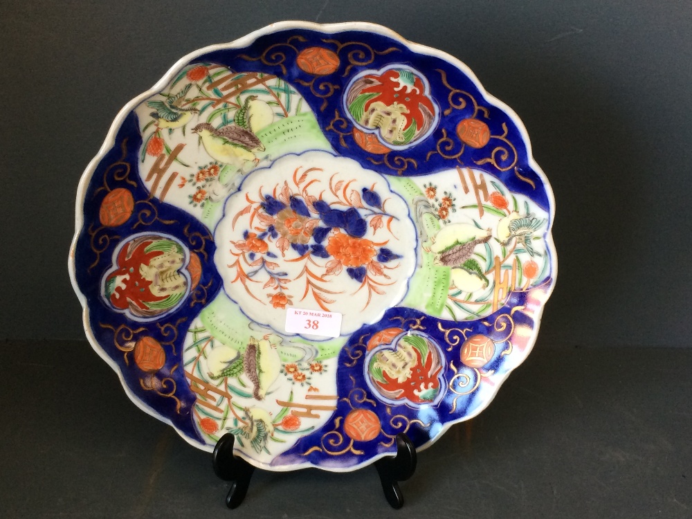 An Imari scalloped dish with a blue background decorated with partridges and floral pattern, 28cm