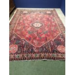 Rug with pink central ground and all over geometric pattern in greens, pinks, blues & browns,