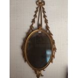 Regency gilded oval wall mirror with ribbon & leaf decoration and finials