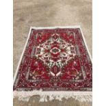 Small traditional rug with dark crimson ground with fine white border and fringes. Central motif