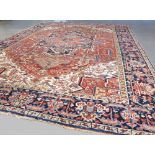 Antique Persian Heriz carpet with central red ground and blue and red borders 3.75 x 2.81m