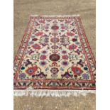 Small rug with all over pretty design of flowers in pinks and blues, cream ground with rectangular