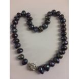 String of black baroque pearls on white metal clasp inset with cubic zirconia's