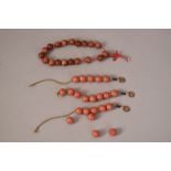 Three strands of Chinese coral beads; together with a string of gold-splashed glass beads.