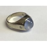 An unusual 14ct white gold cats eye white cabochon sapphire ring