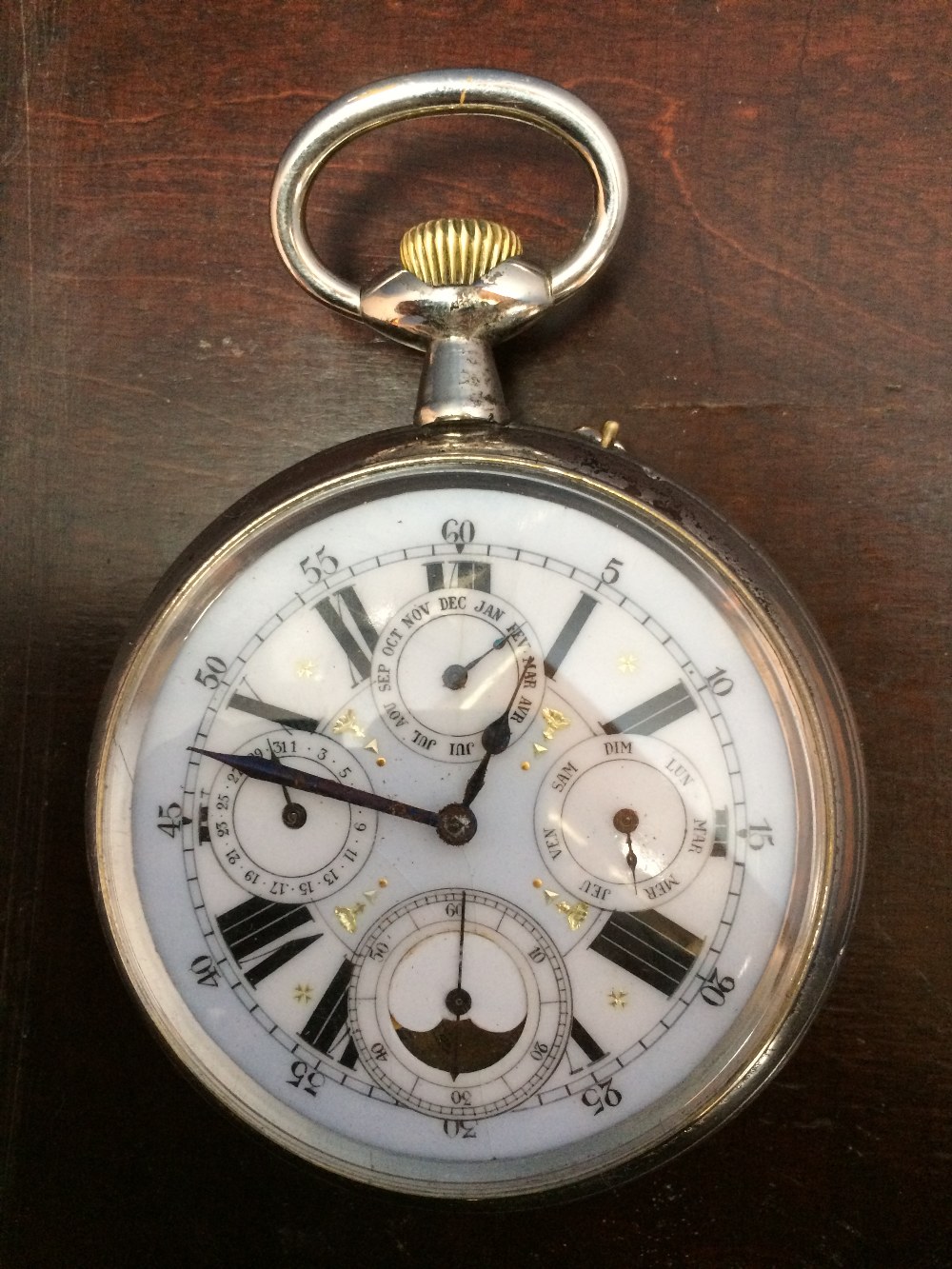 Nickel plated top wind moonphase pocket watch with day, month & week dials