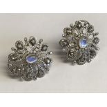 Pair of 18ct white gold earrings the central moonstone surrounded by pear shaped diamonds