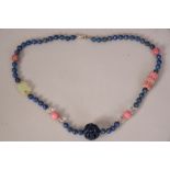 Chinese lapis lazuli beads necklace spaced by four crystal beads and four pink hardstone beads.