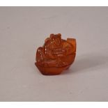 C19th Chinese amber carving of a seated boy 4cm high.