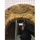 Giltwood, red painted wall mirror, a marble carving of babies in a basket, a modern bronze effect