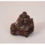 C18th/19th Chinese wood carving of a seated Luohan, bearing two-character mark to base, 5.1cm