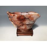 Chinese mottled peach jade libation cup with all over decoration on wooden stand, height of cup