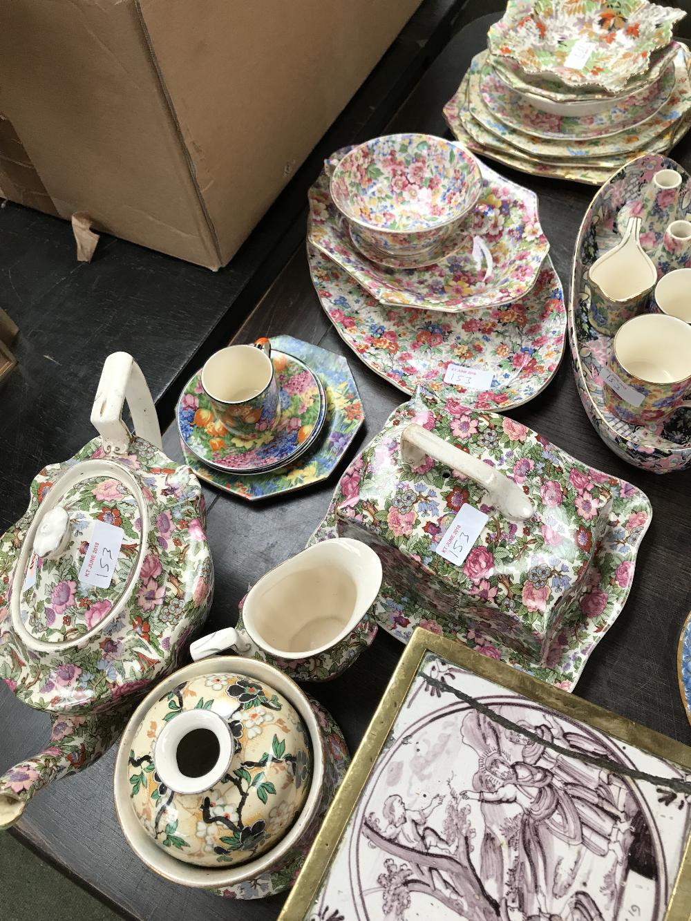 Quantity of floral chintz teawares & pair of fireside ornaments