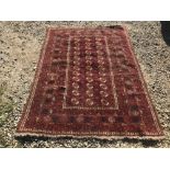 Rug, with dark red ground and cream circular medallions within stylized panel, 187x137cm