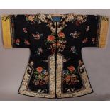 C19th Chinese lady's black silk robe, embroidered with butterflies in flight amongst flower