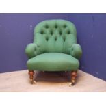 Victorian green upholstered button back arm chair, in turned legs to castors (1 leg needs re-