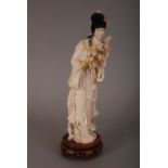 C19th Chinese carved ivory figure of a lady, holding a flower spray and wearing long robes, wood