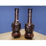 Pair of Chinese bronze onion shaped vases with raised decoration of birds & dragons on carved wooden