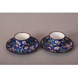 Pair of C18th/19th Chinese painted enamel cups and saucers, painted with bamboo and prunus in a blue