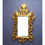 Gilt mirror with scrolls & accanthus leaf decoration; bevelled glass 124Lx73cmW overall